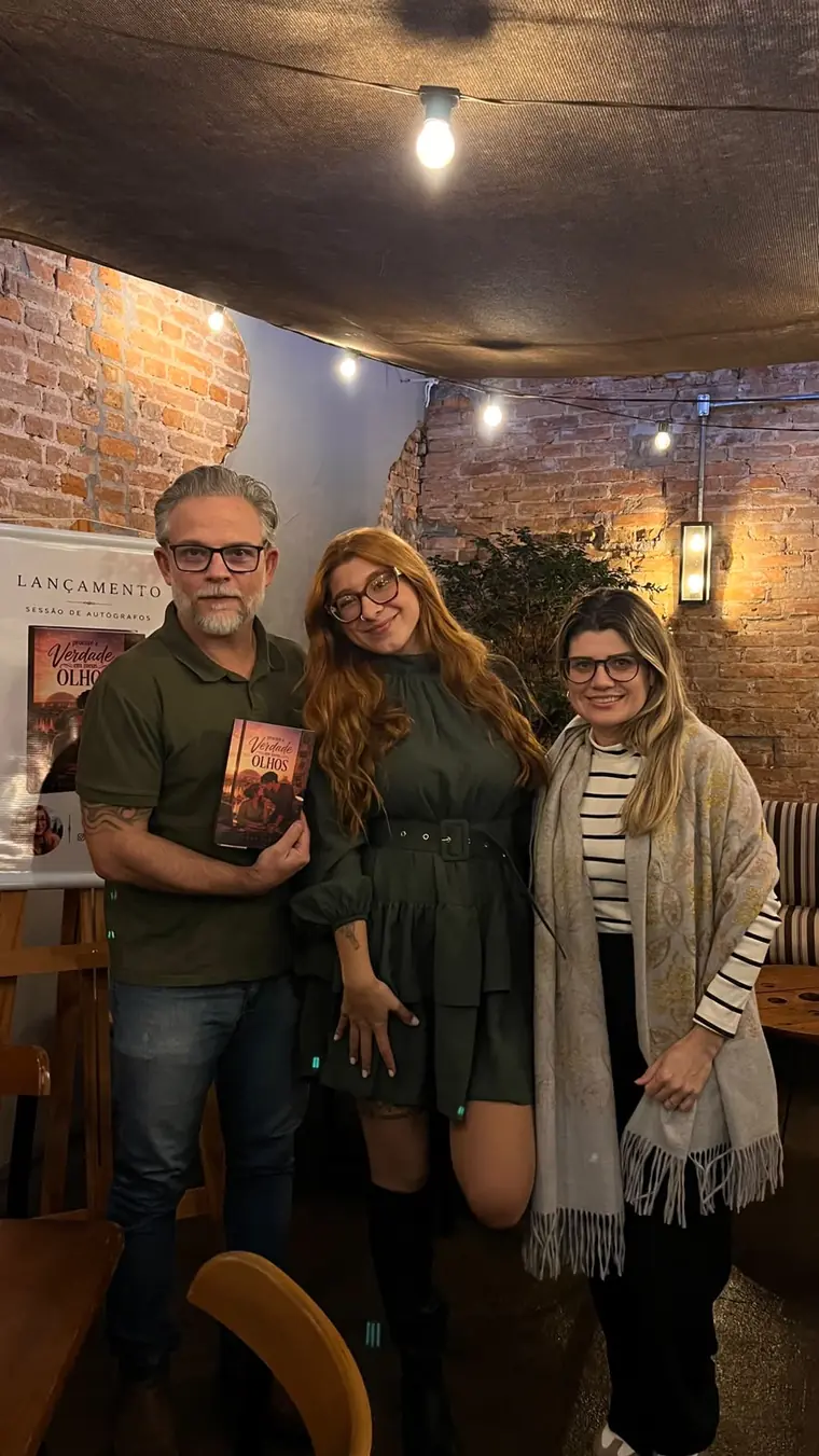 Esther Faria entre dois convidados no lançamento do livro